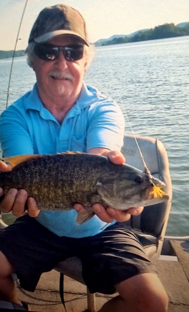 A smallmouth bass, gold blade and tail hanging clear