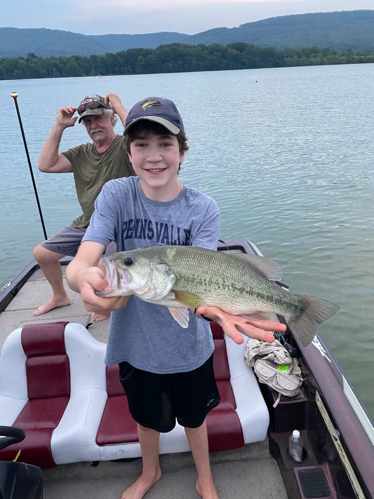 A young angler with a bass off the bow